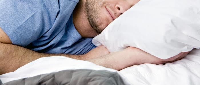 Man comfortably sleeping in his bed