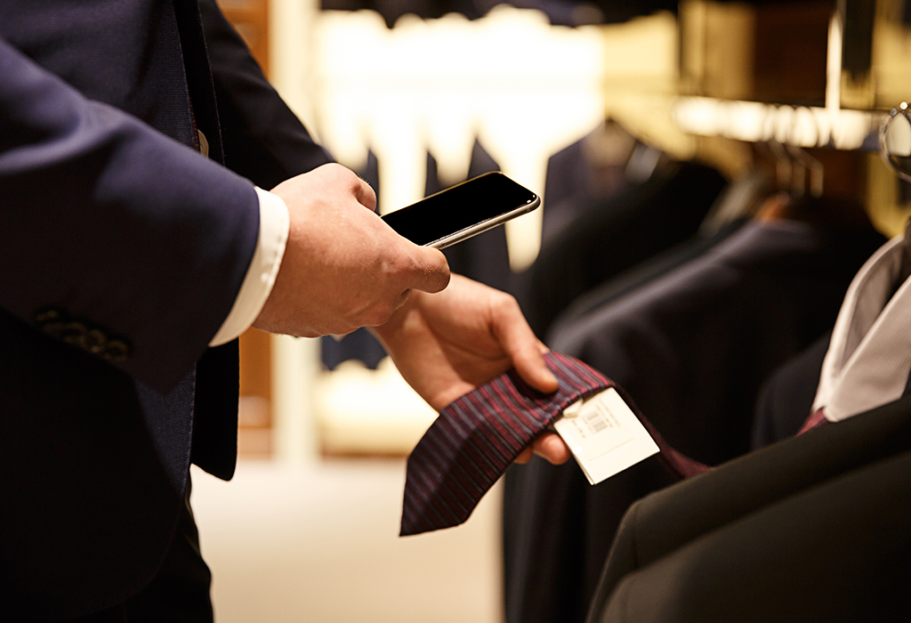 man buying tie and check phone 