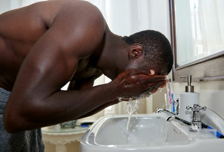 black man washing his face