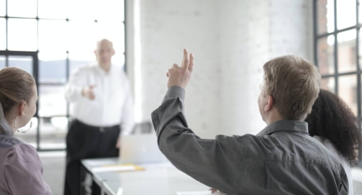 a man raising his hand to ask a question to be more attractive