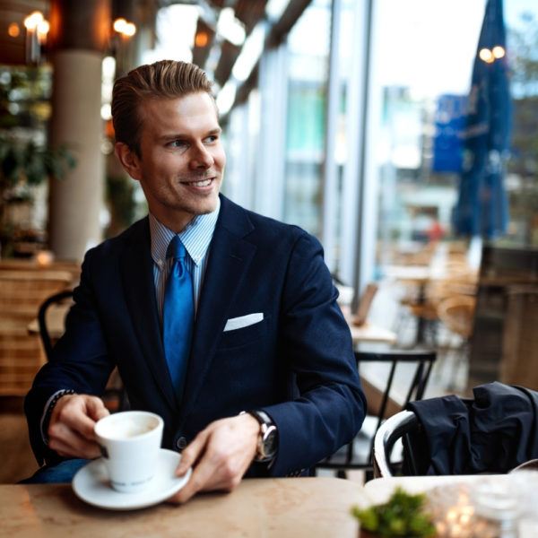 suited man drinking coffee