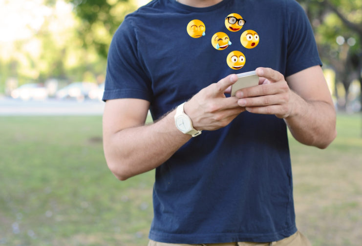 man texts using emojis