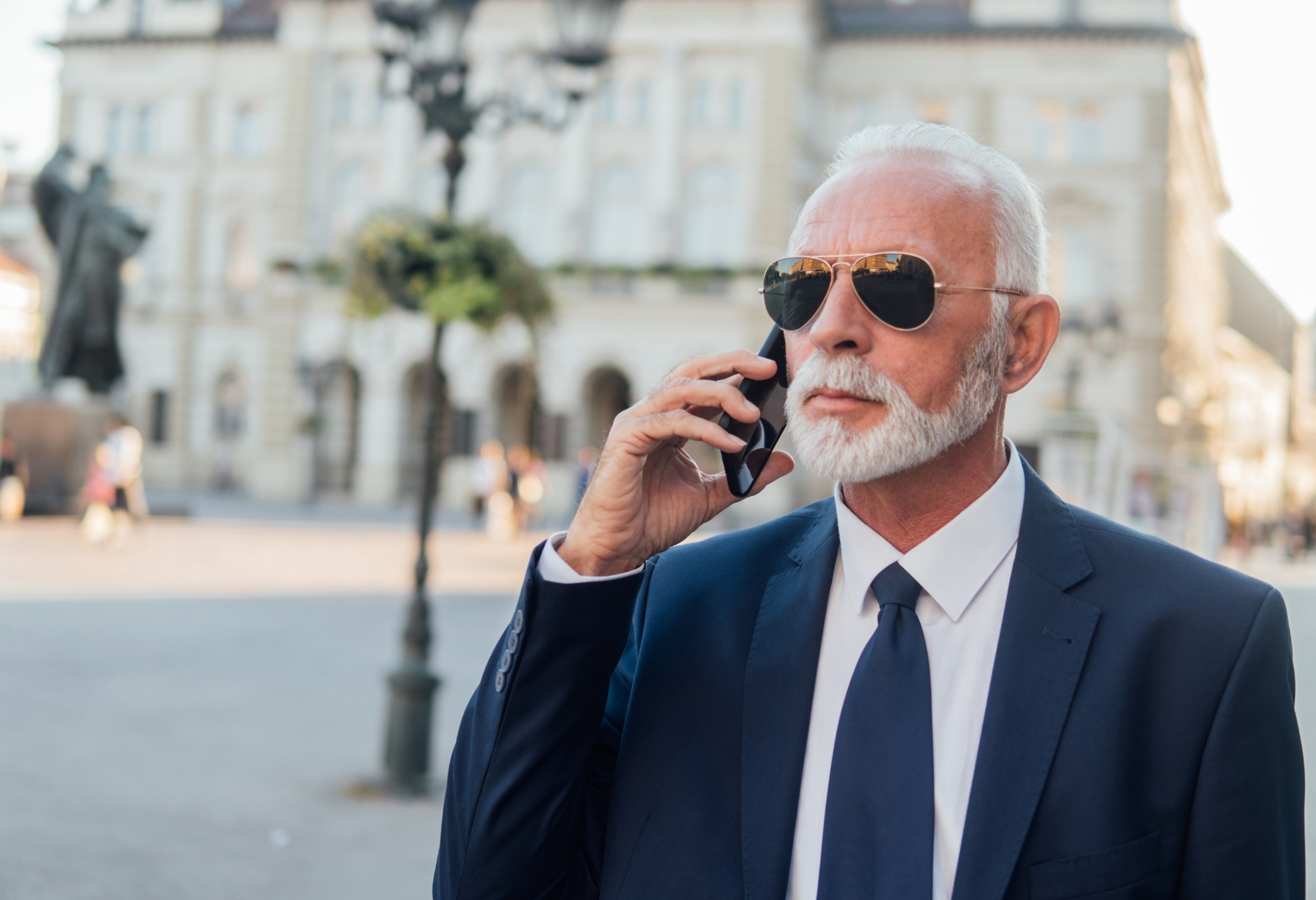 an older man using his phone wearing suit and old man clothing