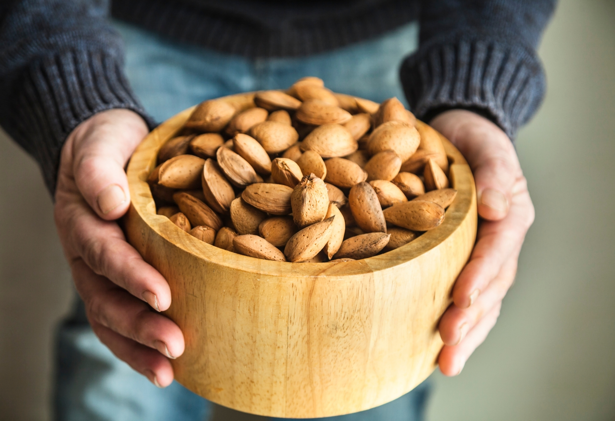 man holding bowl of almonds
