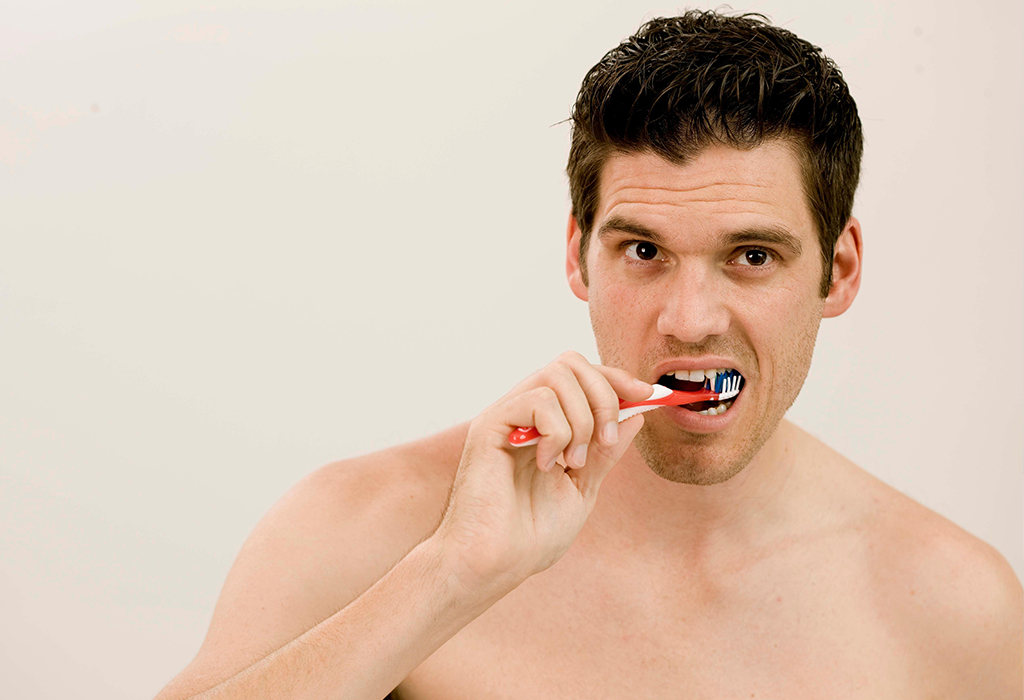 man makes mistake brushing teeth with incorrect technique