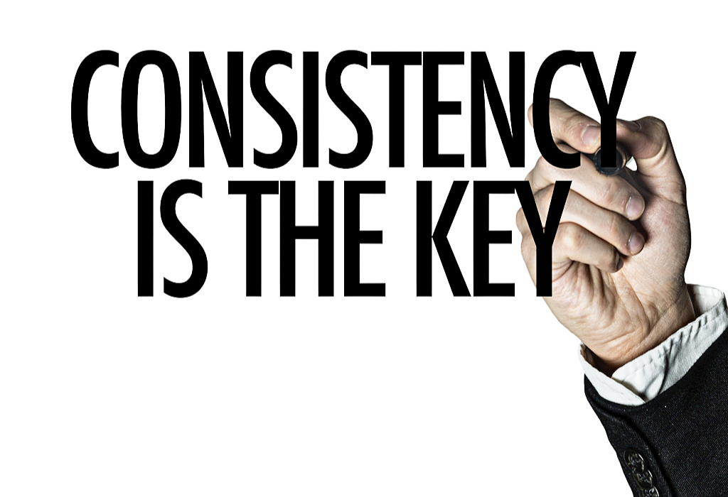 Der Mensch schreibt auf dem Bildschirm „Konsistenz ist der Schlüssel“.