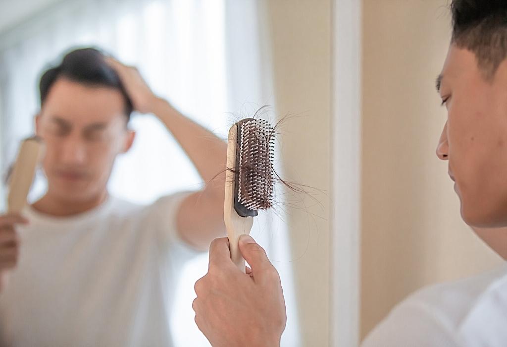 man brushing hair and losing it 