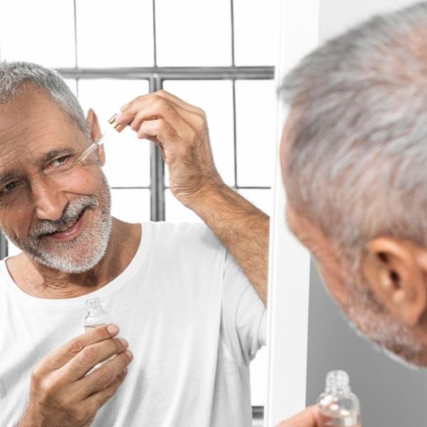 man using shaving oil on face