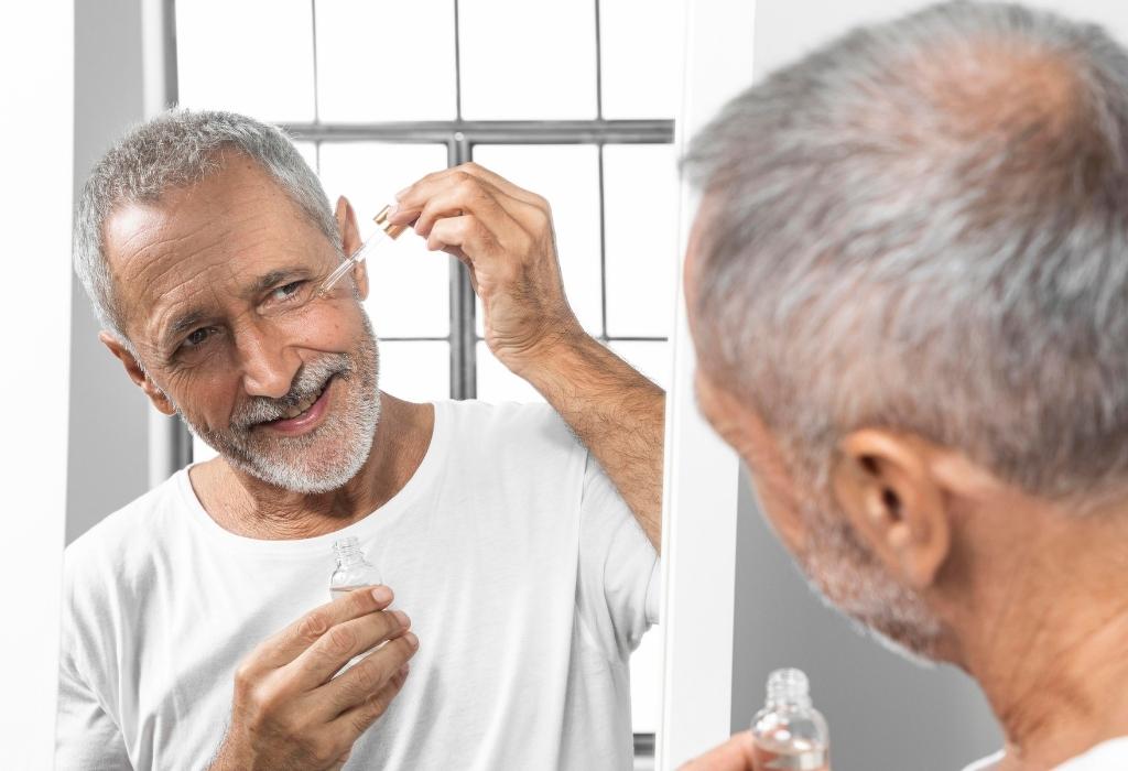 man using shaving oil on face 