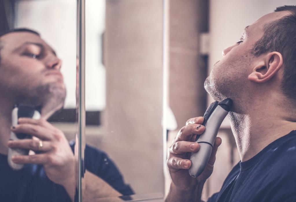 man shaving with electric razor