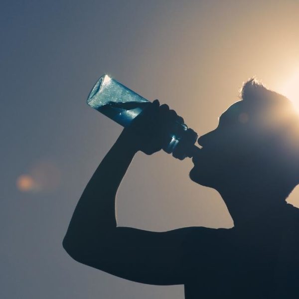man drinking water in the sunshine