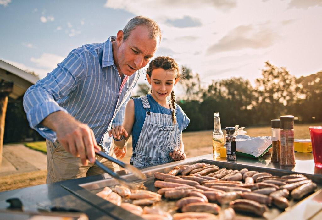 man at grill with daughter - summer dinner ideas