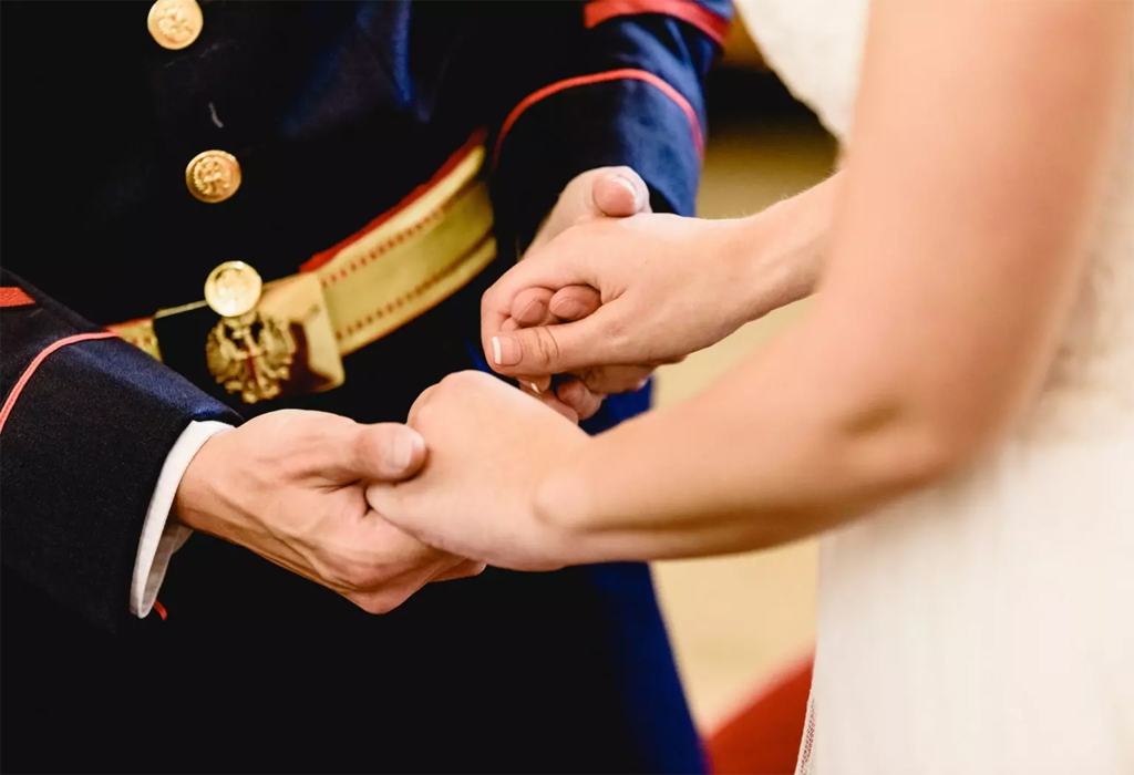 couple holding hands at military wedding ceremony