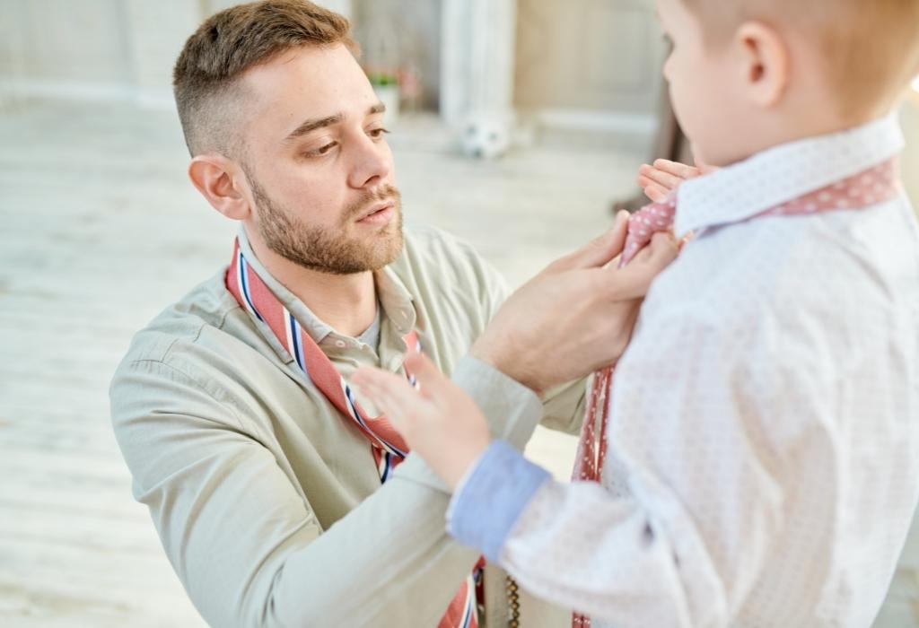 dad helps son tie his tie
