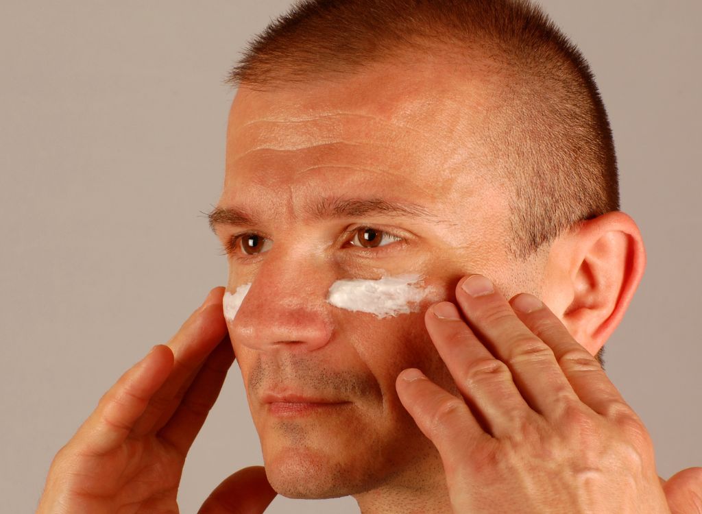 man applying anti aging face cream