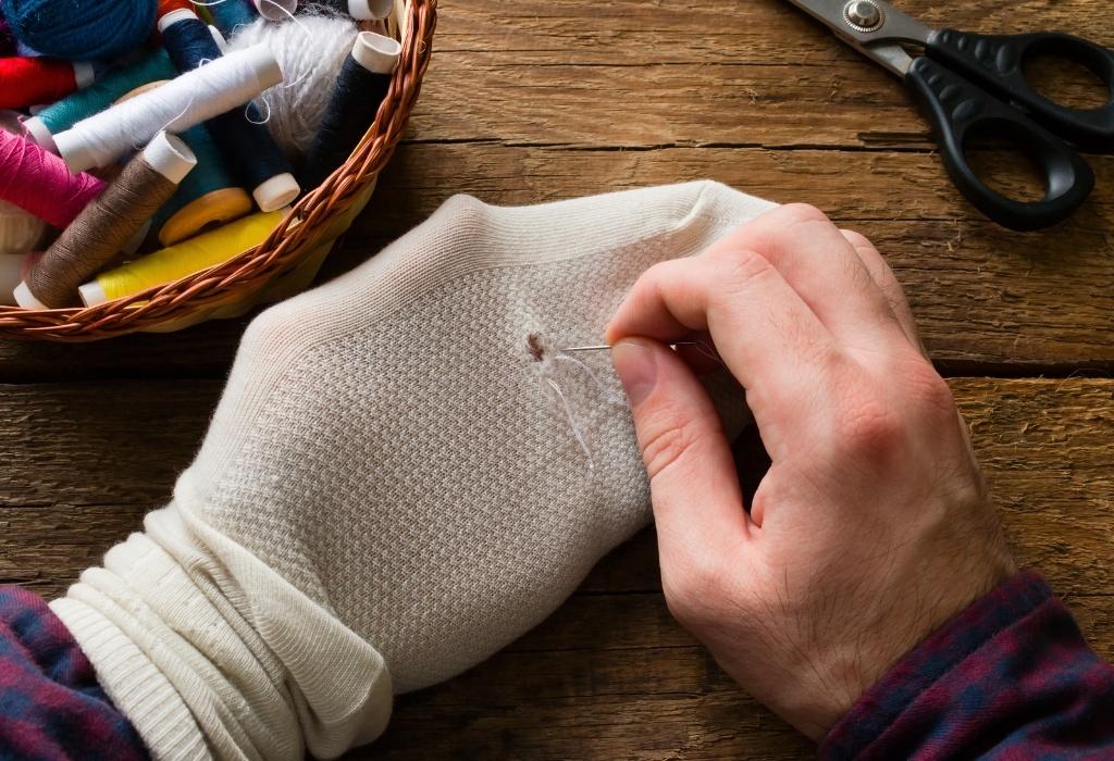 man sewing sock