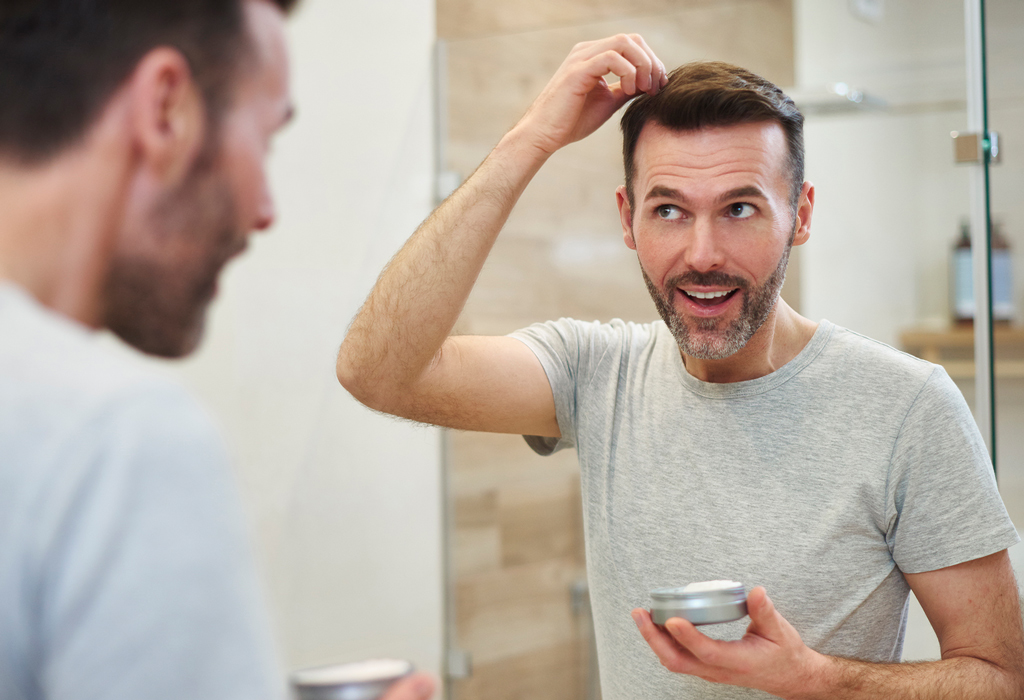 man in bathroom applying hair cream