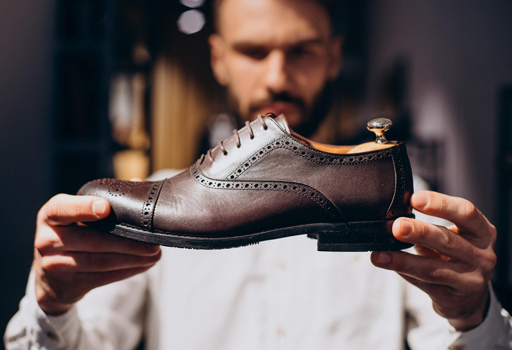 man holding stylish shoe in his hand